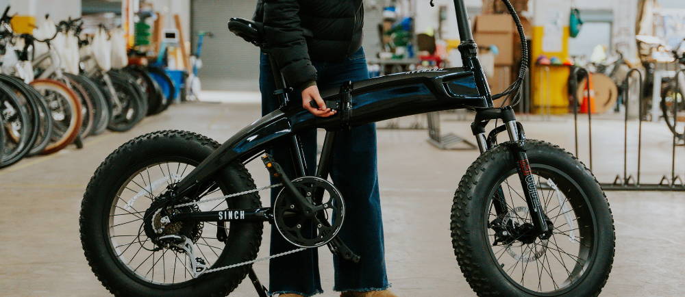 Woman folding Aventon Sinch folding electric bike