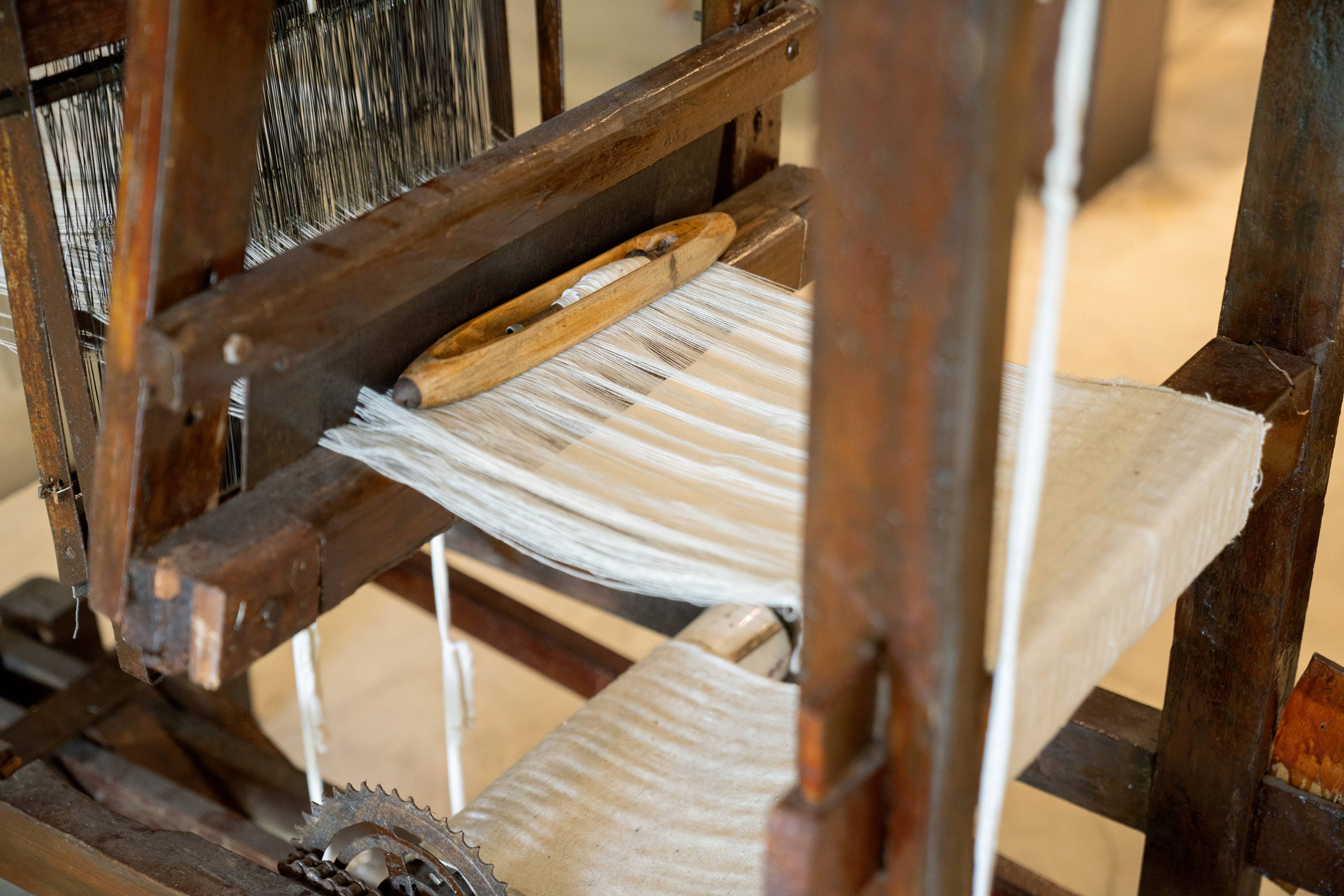 KAPAS Installation by SukkhaCitta in John Hardy Boutique & Gallery at Seminyak. A close up of a traditional weaving machine.  Regenerative cotton and natural indigo dye are used for the yarn.