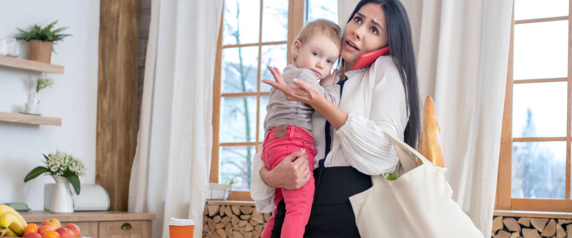 Mother engaged in a heated phone conversation while holding her little child