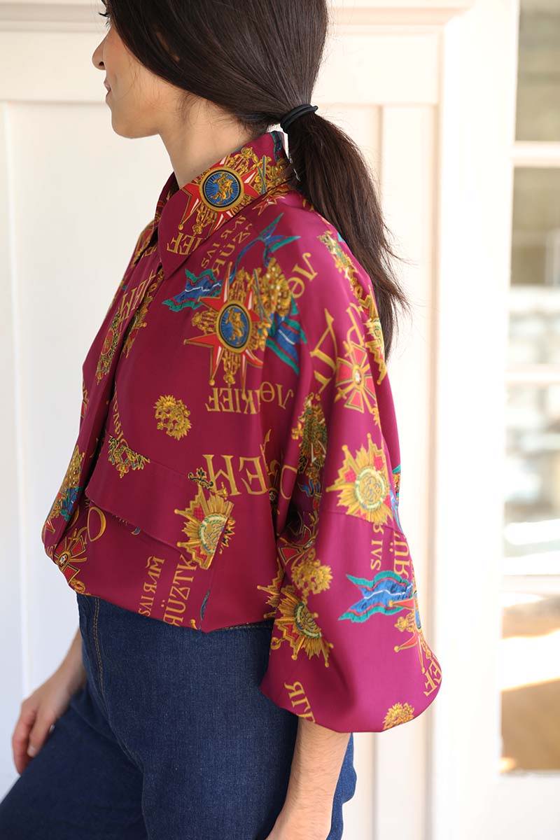 Pristine 80s Oversized Print Silk blouse in a plum color with gold, blue and red details on the print.