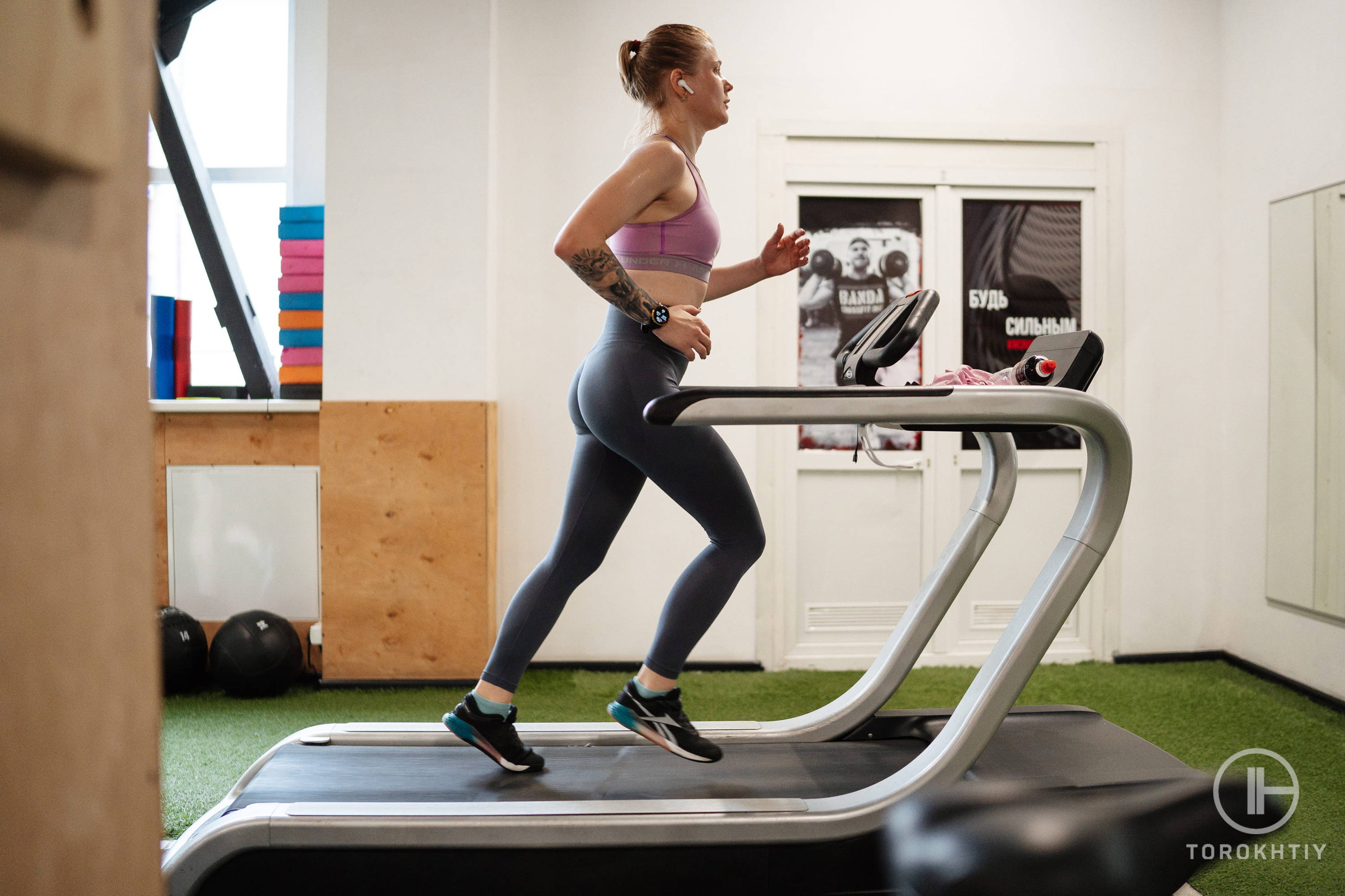 athlete in pink top running on a treadmill at home