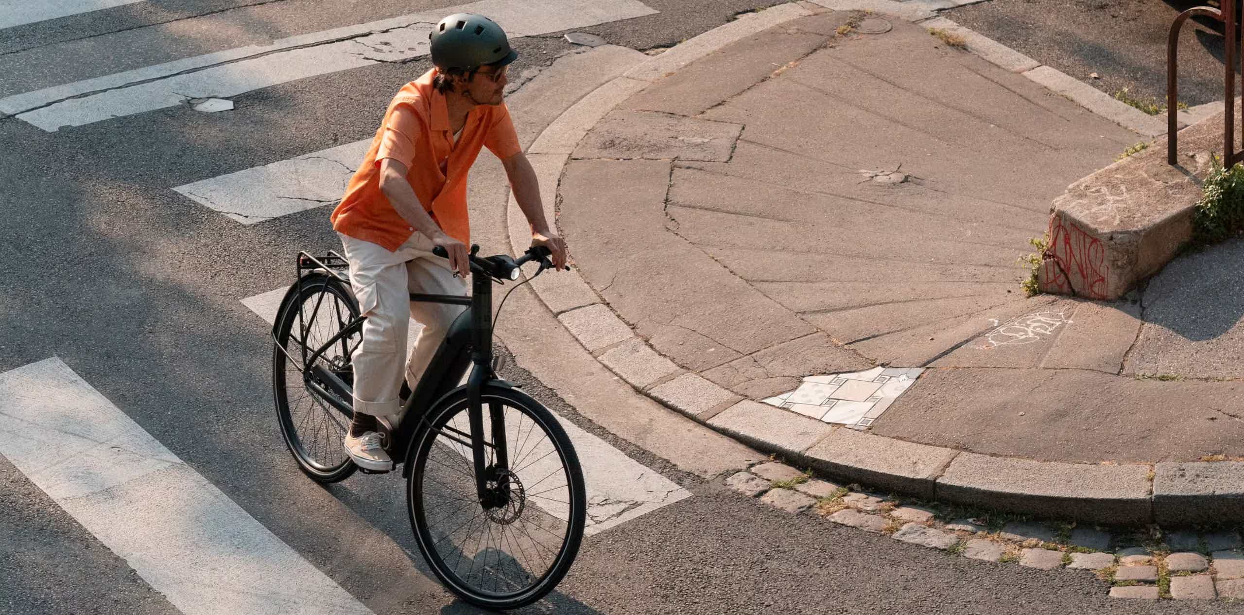 Imagen de recurso de una persona sobre una e-bike rodando por ciudad.