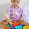 Little girl playing with the Montessori Rainbow Beads.
