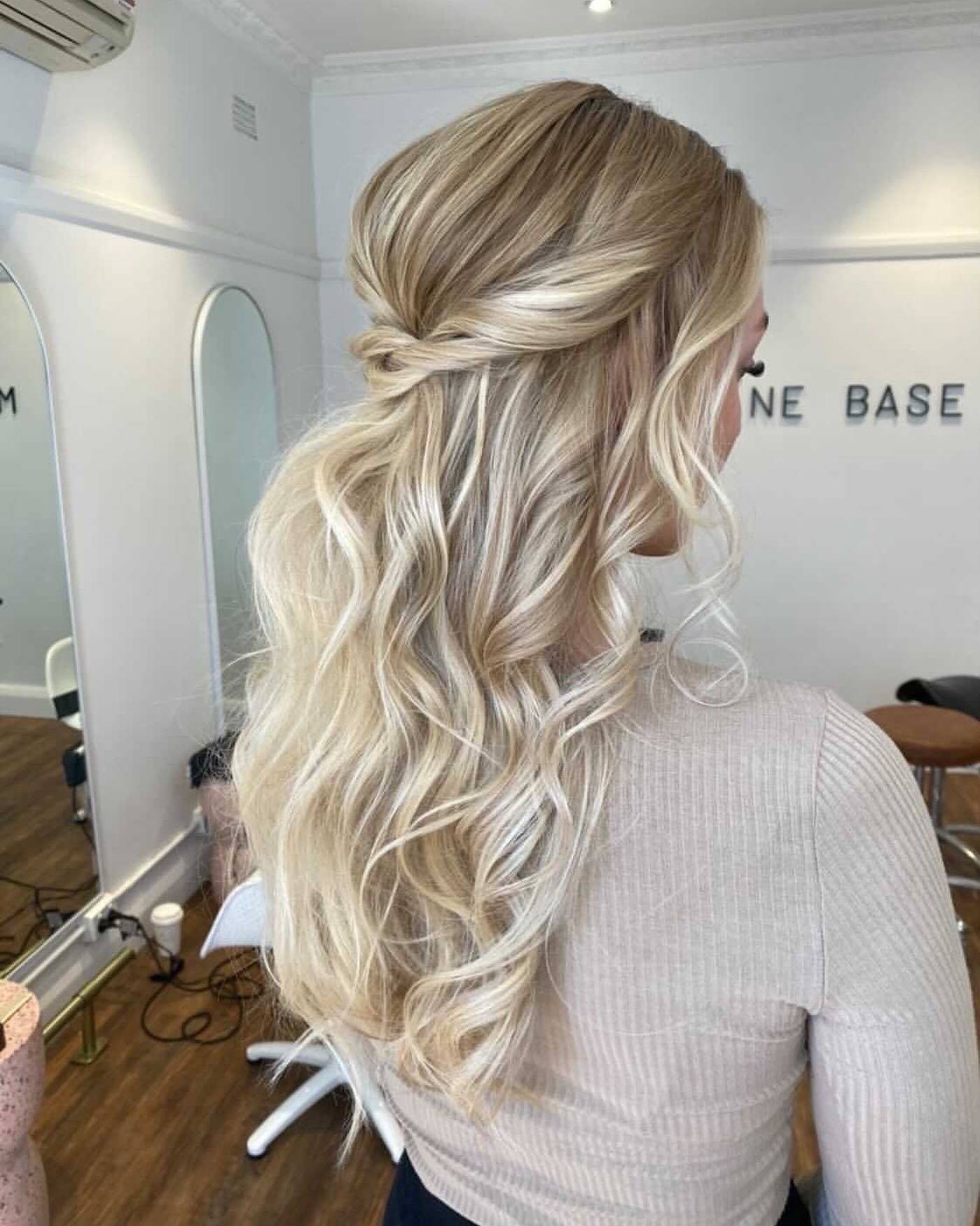 Blonde model in a hair salon wearing Medusa 20" Invisible Tape Hair Extensions. Her hair has been styled in a half up do. 