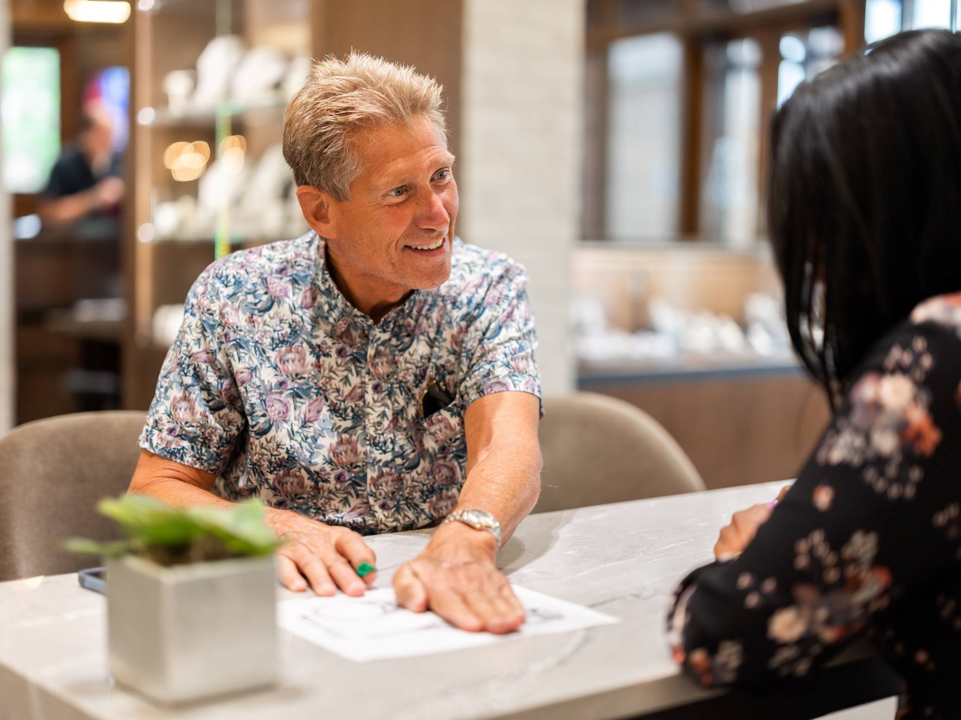 Gerry Turner smiling at consultation desk.