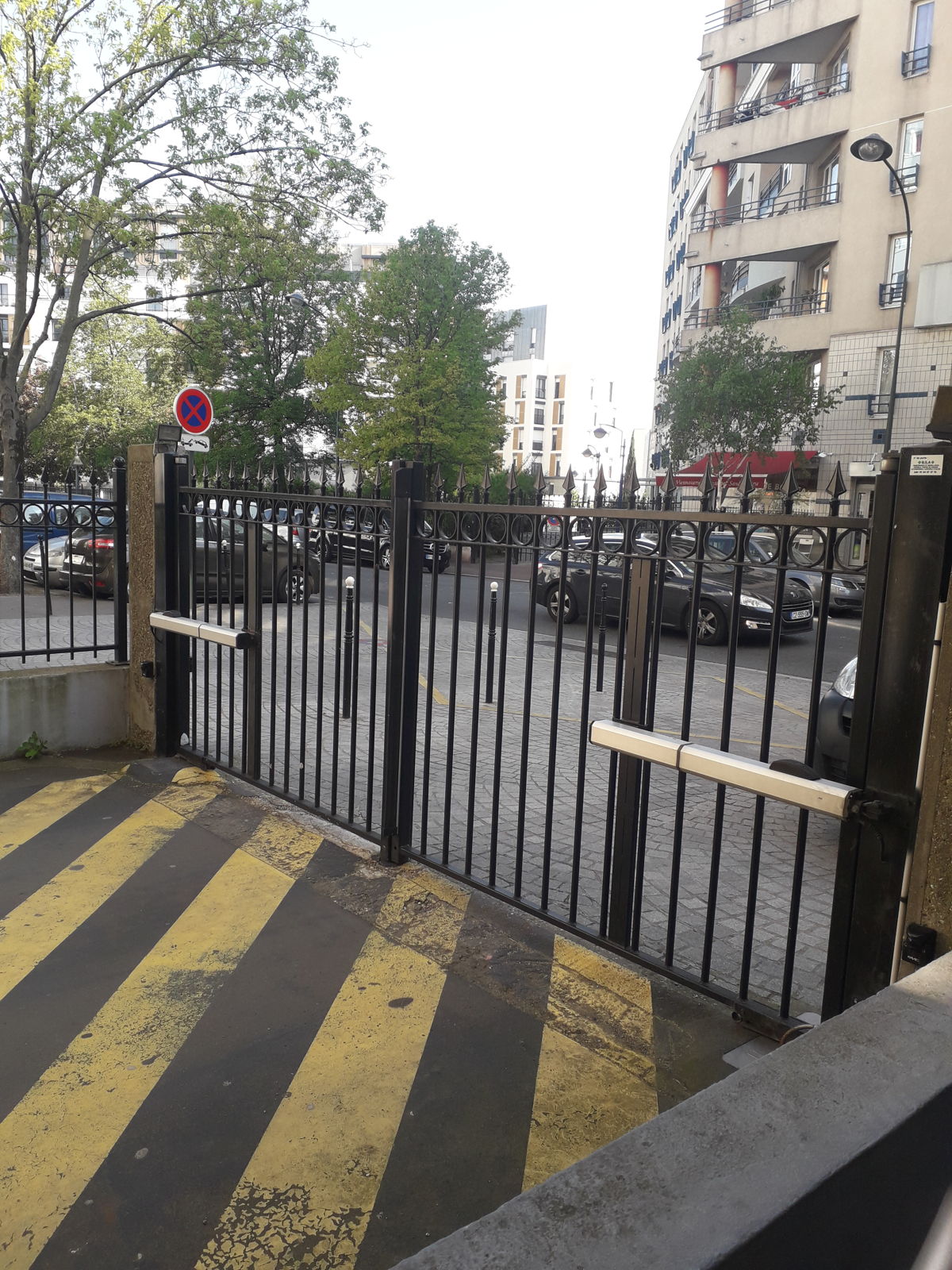 Portail battant motorisé à l'entrée du parking d'une résidence collective