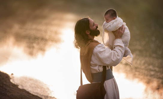 Jesus holding a baby in the air and smiling. 