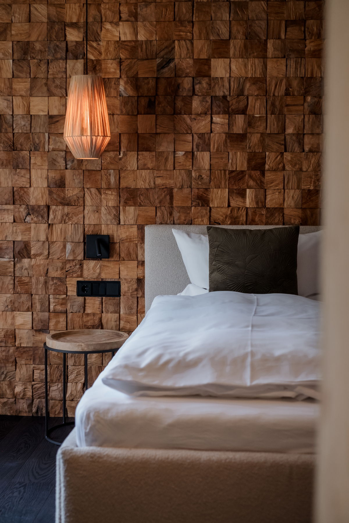 Schlafzimmer mit Doppelbett und Holzpaneelwand im Apartment Waldgeflüster von Hugo & Pepi.