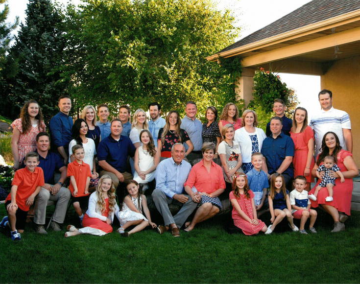 The family and team behind Light Design posing for a photo on lush grass.