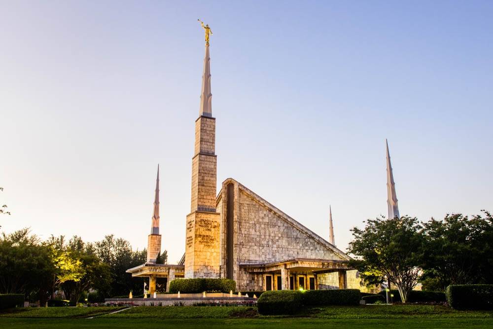 Photo of the LDS Dallas Temple glowing against a clear sky. 