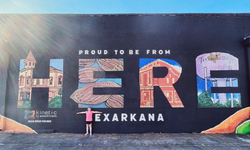 A vibrant mural reads "HERE" and "PROUD TO BE FROM," symbolizing Texarkana's community spirit and identity.