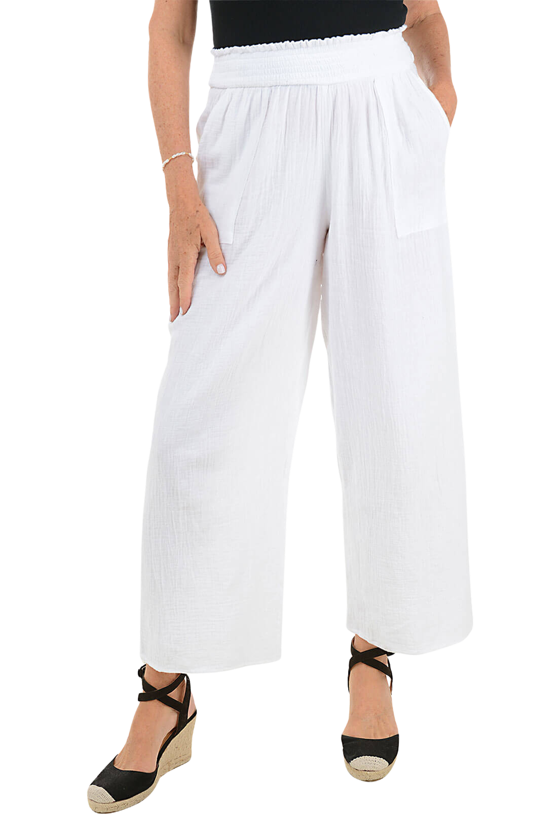 A woman wears a pair of white cotton wide leg lounge pants.