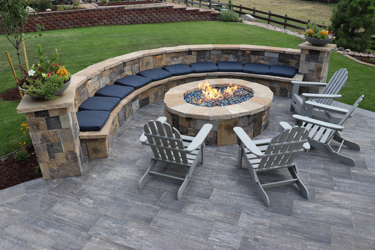 Fire pit area on a patio with a retaining wall and bench