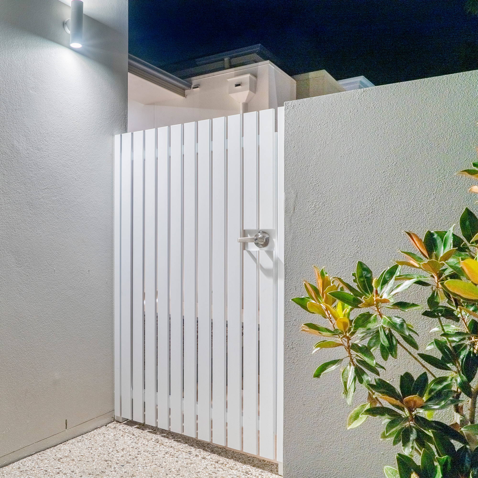 Wall Lights by Havit - Tivah Up & Down Wall Lights by Havit - Tivah Up & Down Wall Light in White illuminating a backdoor of a house.