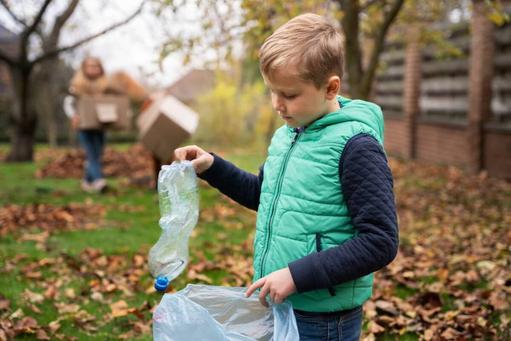 Boy putting a plastic bottle in the cleaning bag.