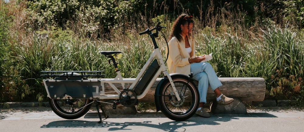 Woman on bench next to Specialized Globe Haul electric cargo bike