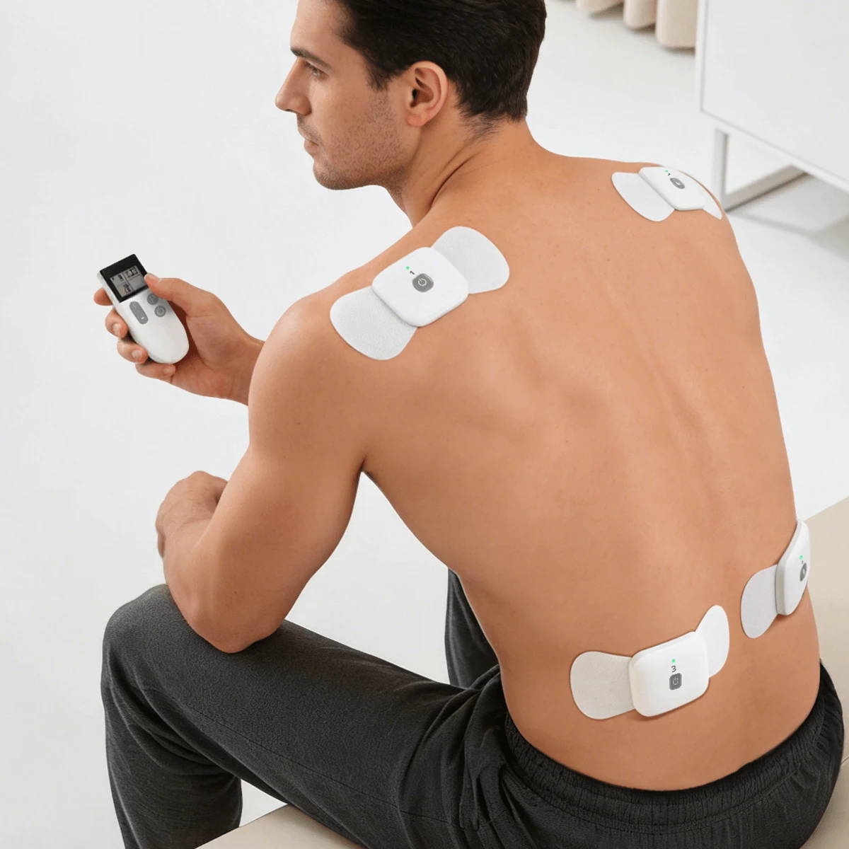 筋肉の弛緩と痛みの緩和のために、背中と脚に4つのワイヤレスWellue TENSセラピーポッドを使用している男性