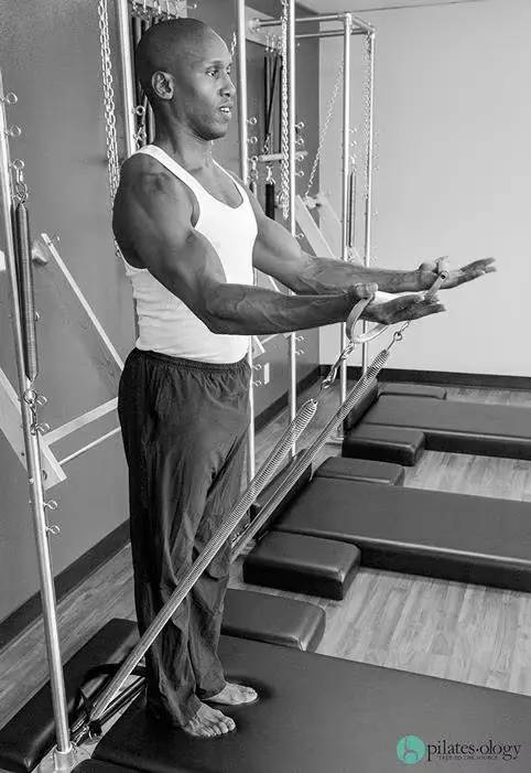 black and white color of Chris Robinson working out on the Gratz Pilates Wall Unit Tower
