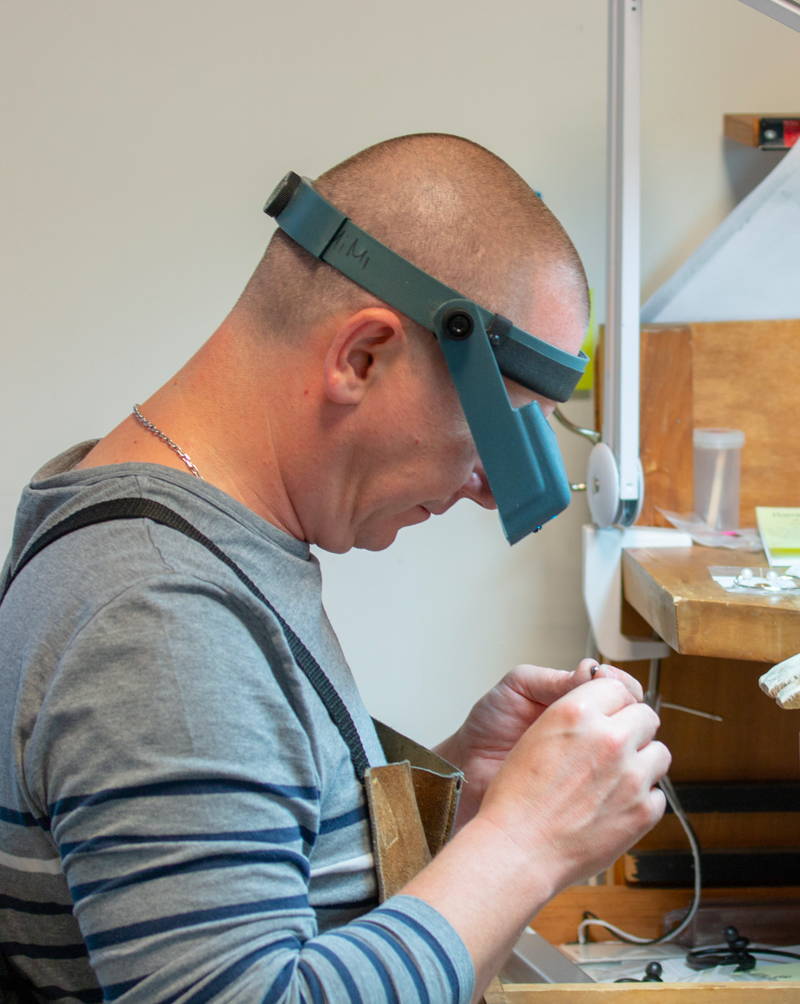 A jeweler at Flamme en rose is busy at his jeweler's bench.