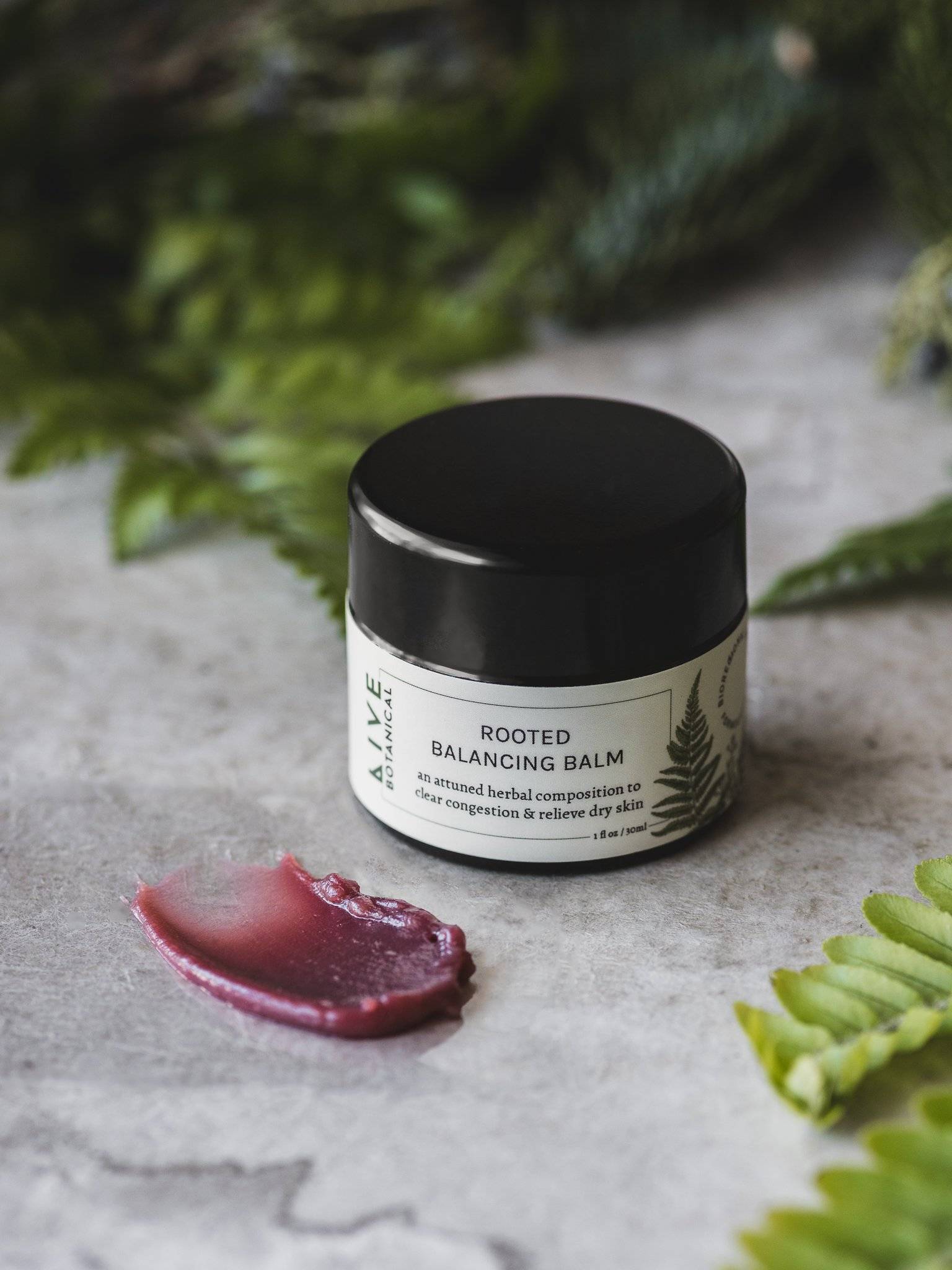 Skin Repair Balm with jar lid opened revealing a golden, soft textured balm