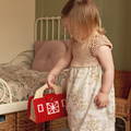 Little girl stacking wooden pieces featured in the Montessori Traveling Farm toy set. 