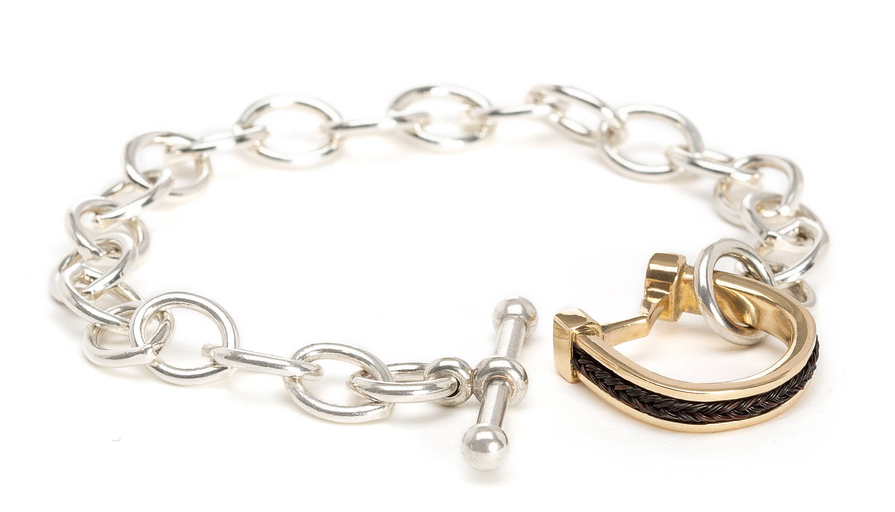 Sterling bracelet with gold horseshoe toggle.  Inset horsehair braid.