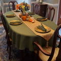 green oval english linen tablecloth on a table decorated with pumpkins and flowers