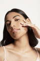 woman touching her face with illuminated skin