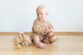 Little boy sitting and playing with wooden Montessori toys. 