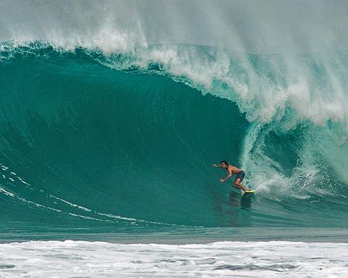 Greg Long wearing Patagonia board shorts crushing a 20ft barrel surfing