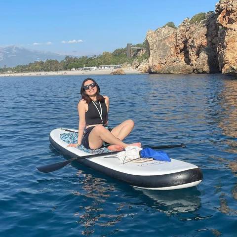 Girl sitting on her blow up paddle board and smiling