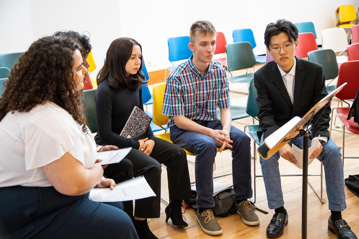 A group of young LA Phil composer fellows examines a music stand