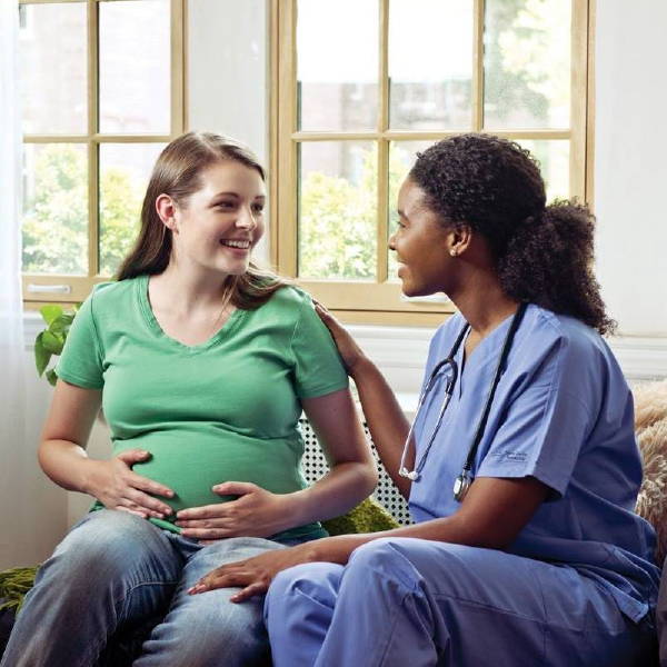 A doctor sitting with a pregnant woman