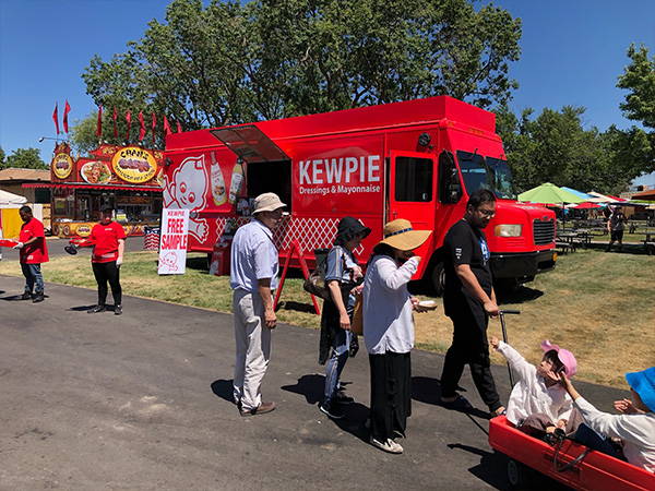 Kids in a wagon come to the Kewpie truck