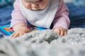 Baby exploring a sensory bag during tummy time for mess-free sensory play