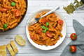 Tomato pasta on a table with a fork