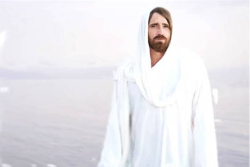 Jesus in a white robe standing in front of a calm body of water.