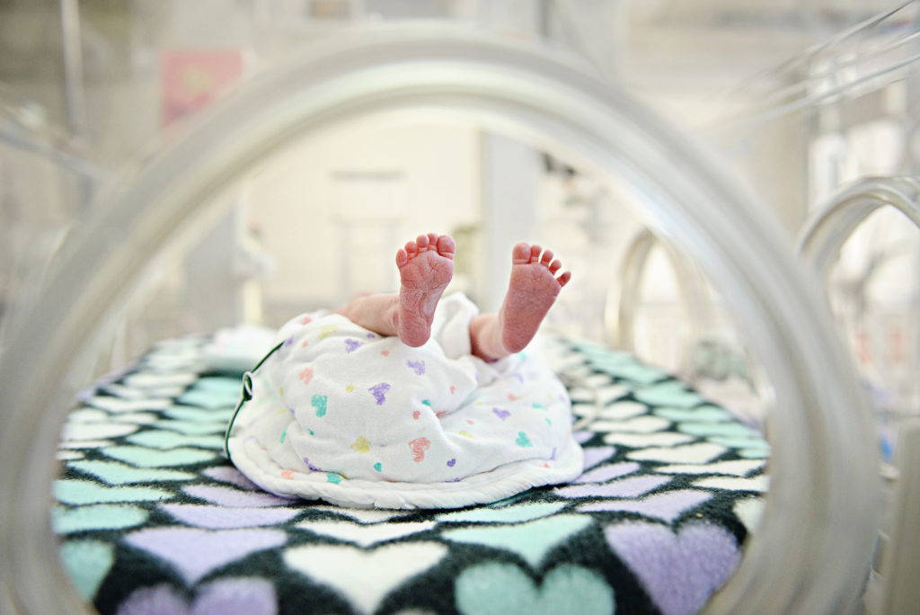 preemie feet in isolette porthole photographed in NICU