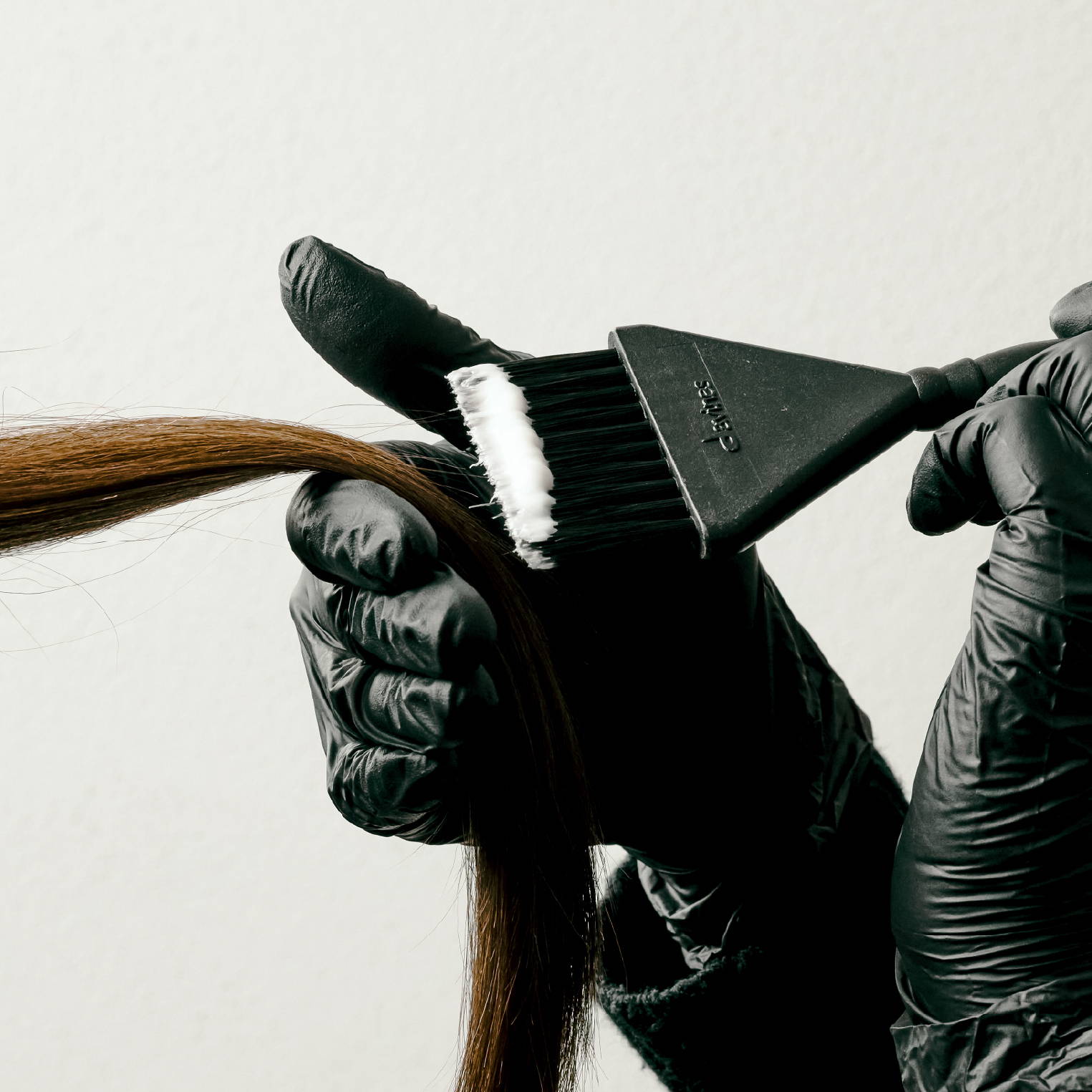 Hair getting lightened with bleach on a brush