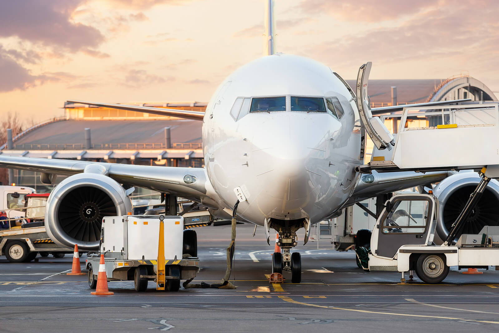 Close-up detail view of high loader cargo catering service truck loading commercial passenger aircraft with food sets and parcel shipping. Airport plane maintenance handling. GPU connect and cleaning