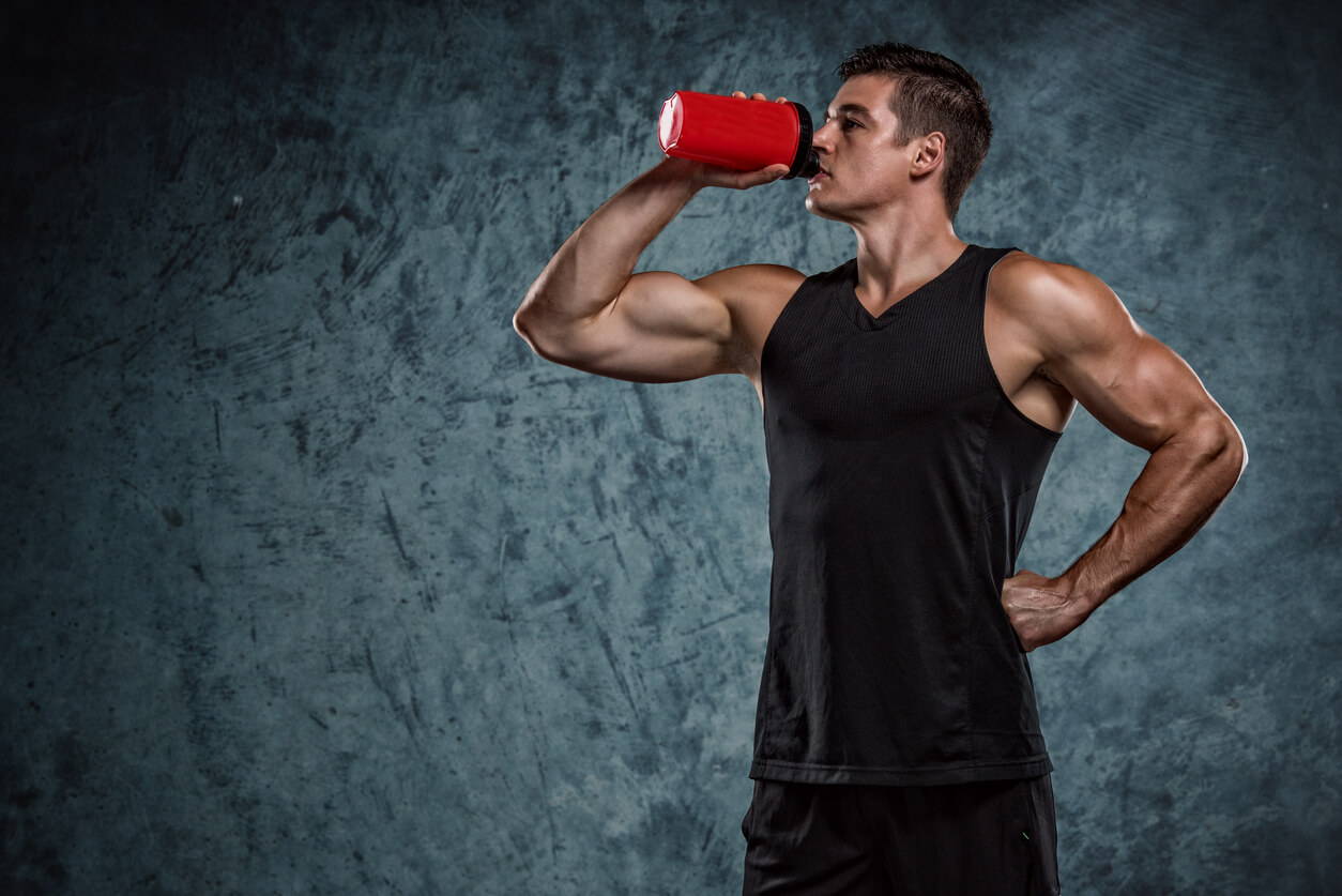 athlete and the bottle of protein shake Men Using Pre Workout