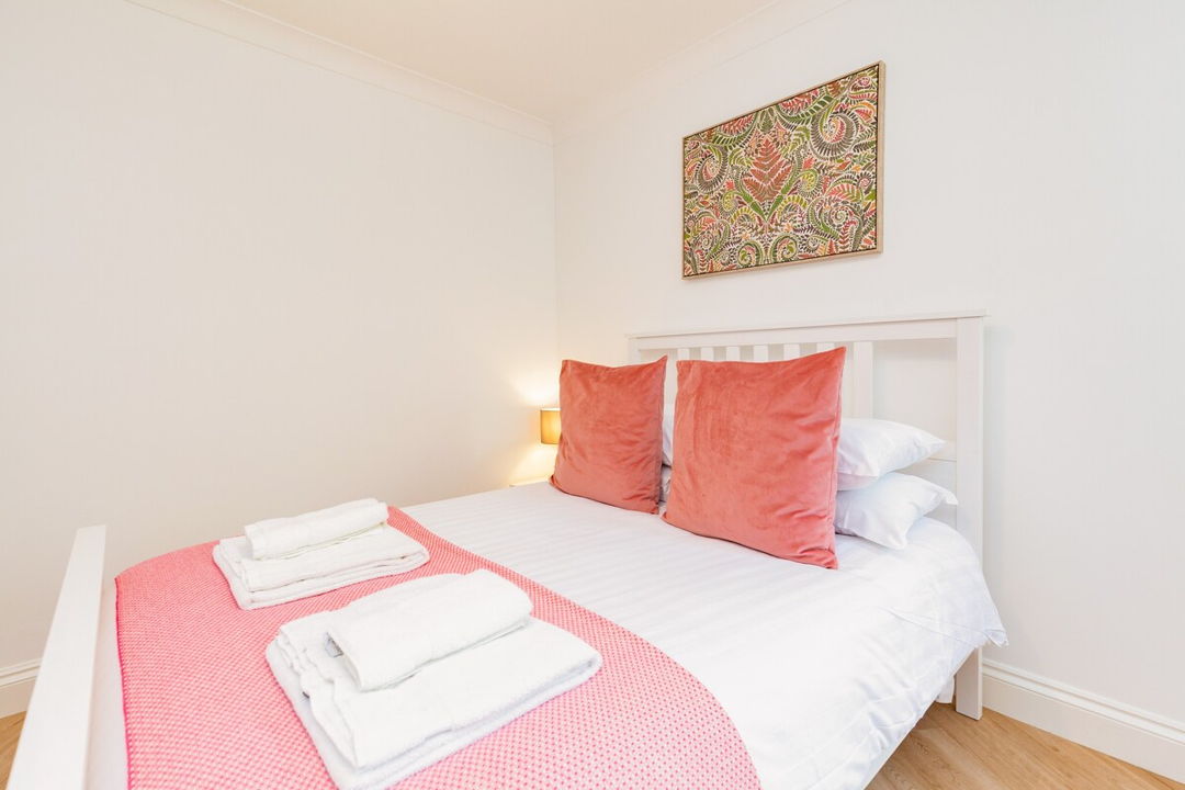 Bedroom with large double bed with extra linen