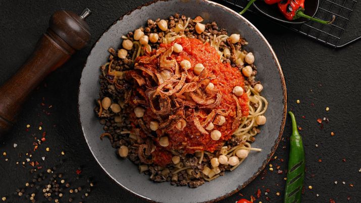 Koshari, flavorful Egyptian street food dish with mixed grains, lentils, and sauces