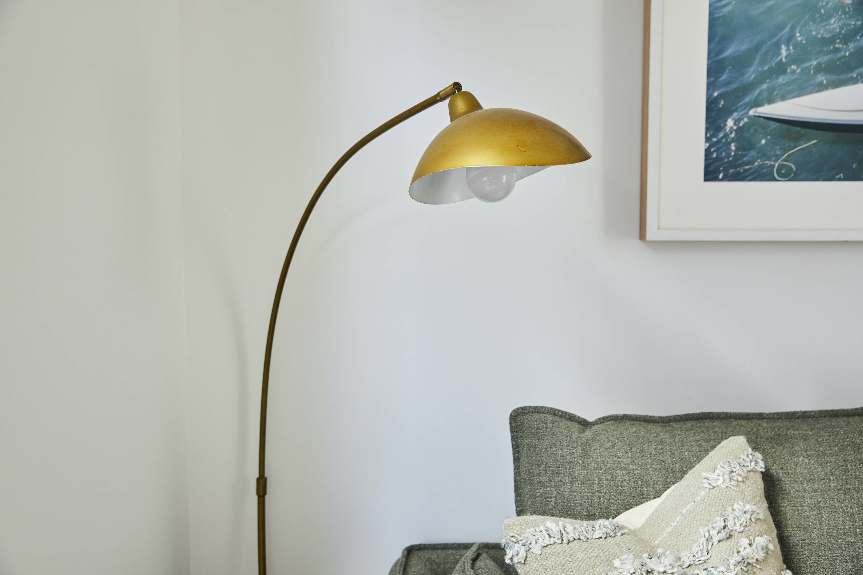 A TV-Mirror hanging on the wall of a coastal, elegant bedroom setting 