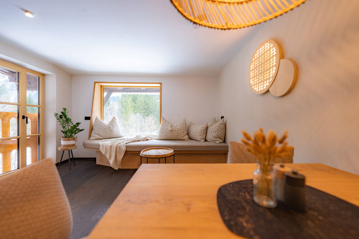 Wohnbereich mit Holztisch und dekorativer Leuchte im Apartment Vogelfrei von Hugo & Pepi.