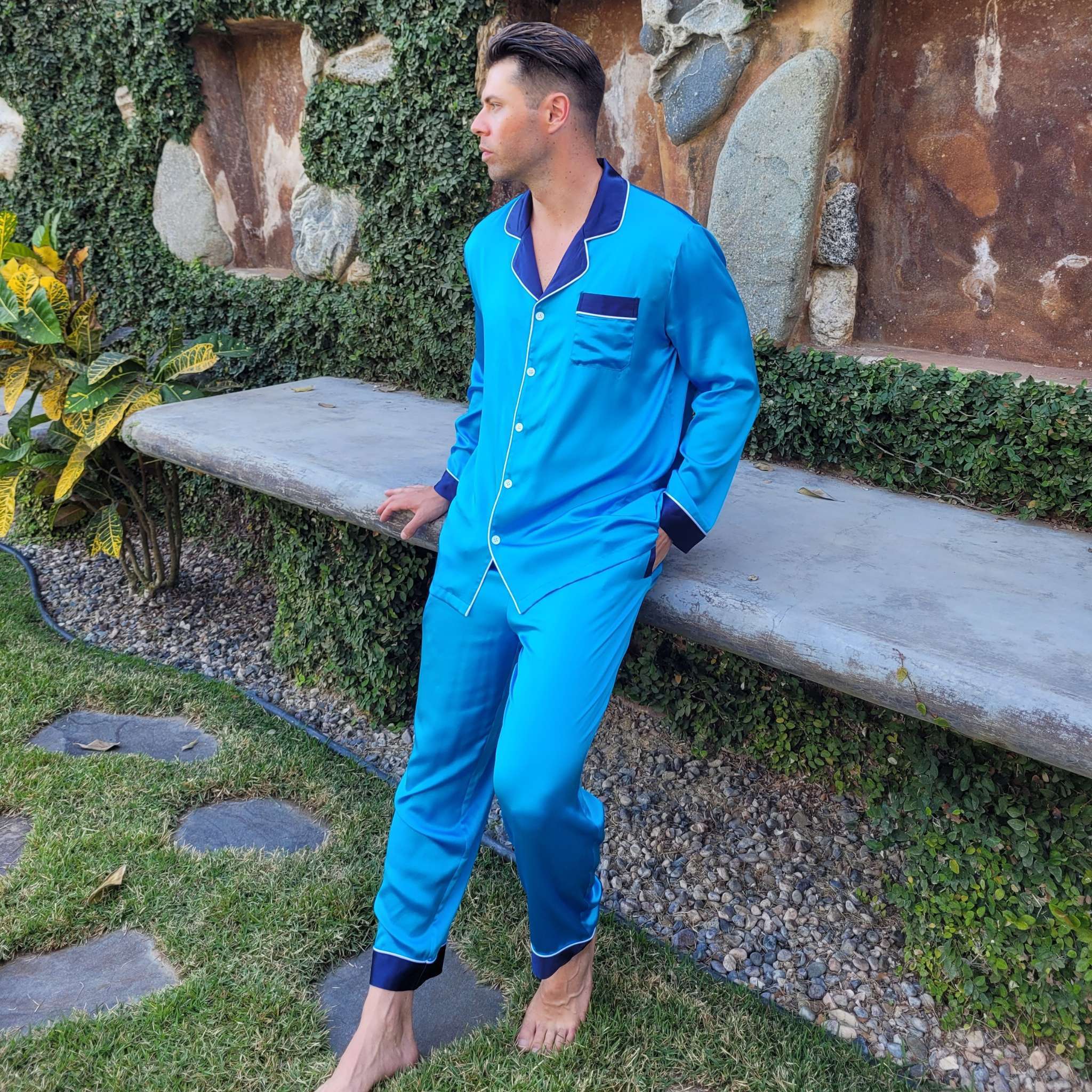 photo of a model sitting in the sun while wearing blue silk pajamas