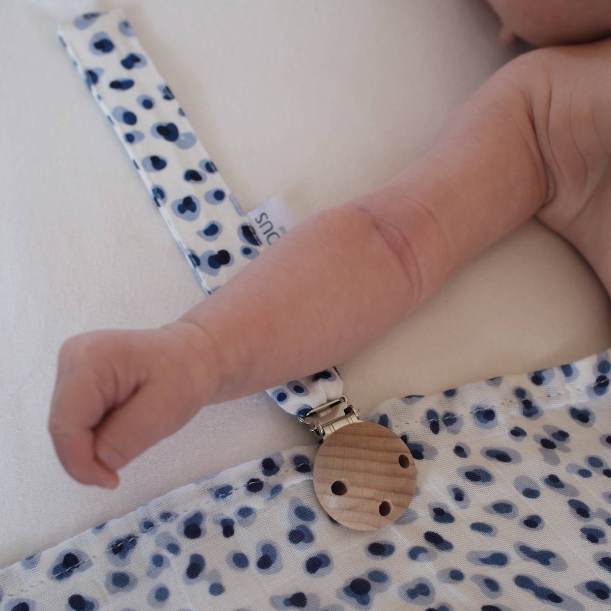 Attache-tétine pois bleu blanc élégant de la marque suisse 'Joli Nous', un accessoire premium pour bébé, alliant design raffiné et qualité exceptionnelle