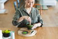 A woman making matcha with a bamboo whisk
