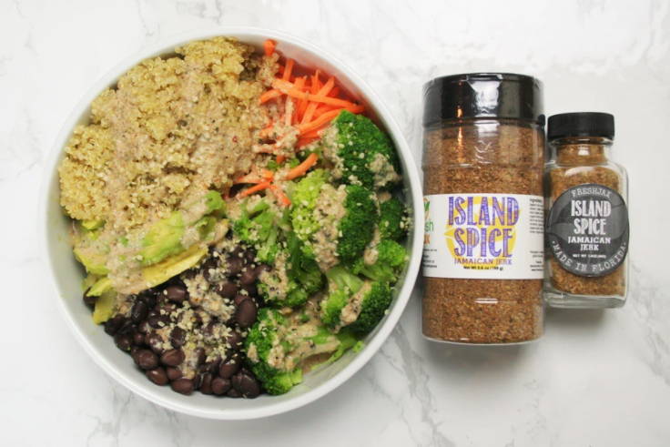 A large Jamaican jerk protein bowl next to two bottles of FreshJax Organic Island Spice Jamaican jerk seasoning.