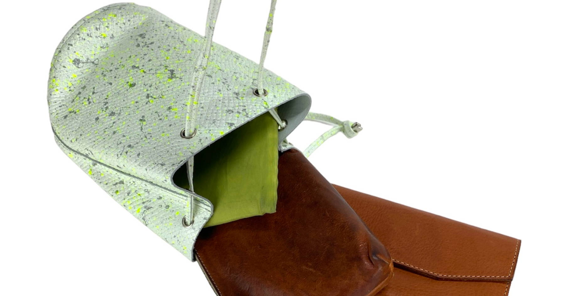 黄緑と深緑の模様がついたペールグリーンの巾着バッグからノートなどがはみ出している。